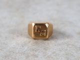 an image of a gold signet ring on a white surface