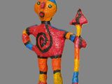 brightly colored figurine of a man on a skateboard holding a stick