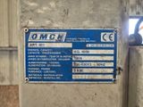 une pancarte apposée sur le côté d'une machine sur laquelle est inscrit « omc »
