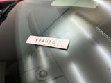 a sticker on the windshield of a car that is parked in a parking lot