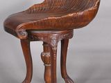 an old wooden chair with a curved seat on a gray background