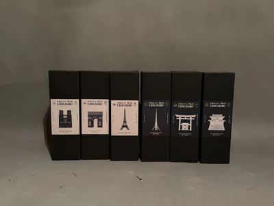 four black boxes of wine sitting on top of a white table