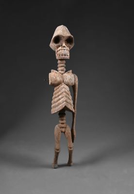 une statue représentant un squelette humain avec une grosse tête et un torse imposant