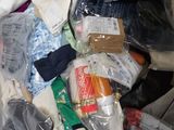 a pile of clothes and other items in the back of a car