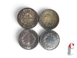 four different types of coins are shown on a white surface