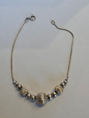 un collier de perles argentées sur un fond blanc