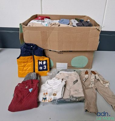 une boîte en carton sur laquelle sont posés des vêtements et une veste
