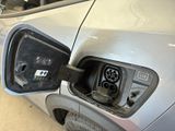 a silver car that has an electric charger attached to it
