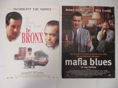 Trois affiches de cinéma représentant des hommes en costume-cravate sont accrochées au mur