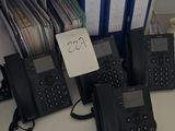 Plusieurs téléphones sont alignés sur un bureau dans un bureau.