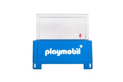 La boîte bleue de Playmobil est posée sur une table blanche.