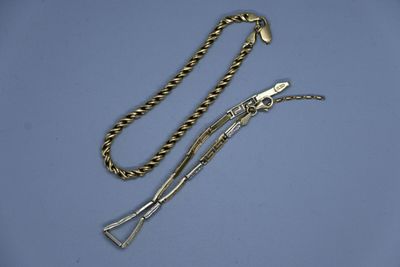 un collier en or avec une longue chaîne sur fond bleu