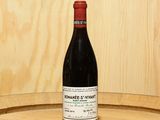a bottle of wine sitting on top of a barrel