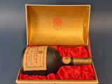 une boîte ouverte contenant une bouteille de vin, posée sur une surface bleue