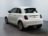 the small white car is parked in a large white room