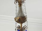 a gold chandelier with blue crystals hanging from the ceiling