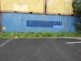 a parking lot with a blue wall and a yellow building