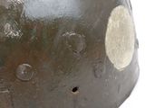 an old helmet with holes on the side of it on a white surface