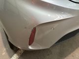 a car that has been dented and is parked in a parking lot