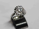 une bague sertie d'un diamant, posée sur une table