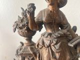 a statue of a woman sitting on a rock with a guitar
