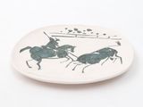 a white plate with a picture of two horses and a man on a horse