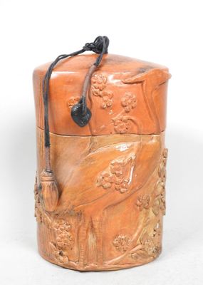 une petite boîte en bois avec une poignée sur une surface blanche