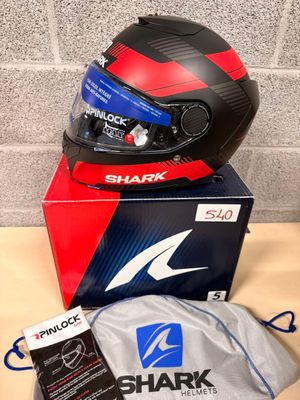 a shark helmet on top of a box next to a bag