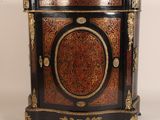 une armoire noire et rouge ornée de décorations dorées