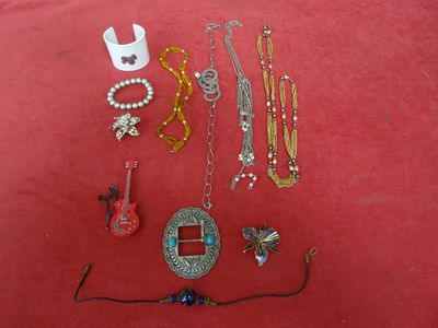 a lot of jewelry that is laying out on a red surface