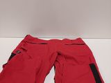 a pair of red ski pants sitting on top of a white table