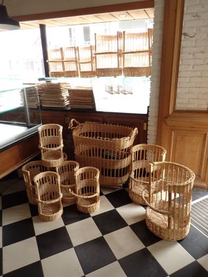 Plusieurs paniers en osier sont alignés sur le sol à carreaux d'un magasin
