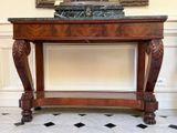 a marble top table in a room with a painting on the wall