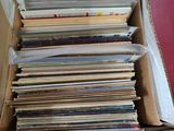 a lot of books in a cardboard box on the floor