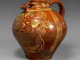 a brown vase with a gold design on it