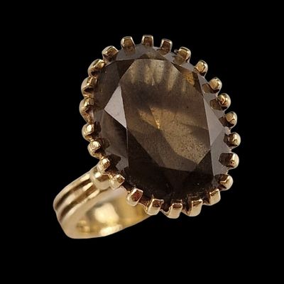 une photo d'une bague en or sertie d'un gros quartz fumé
