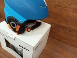 a blue helmet sitting on top of a box on a wooden floor