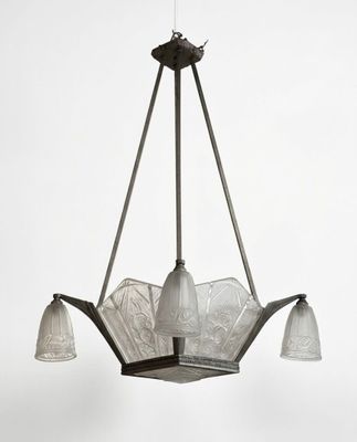 un lustre Art déco composé de trois abat-jours en verre suspendus au plafond