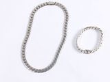 silver necklace and bracelet set on white background with copy space