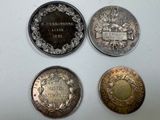 four different types of silver and bronze coins on a white surface