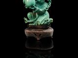 une sculpture en jade vert représentant un dragon sur un rocher