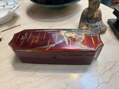 a small box sitting on a table next to a statue