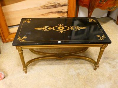 a black and gold coffee table with gold decorations on it