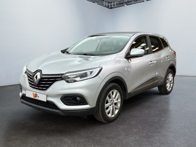 une voiture argentée garée dans un garage, près d'un mur blanc