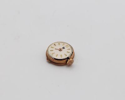 un gros plan d'une montre sur une surface blanche avec un fond blanc