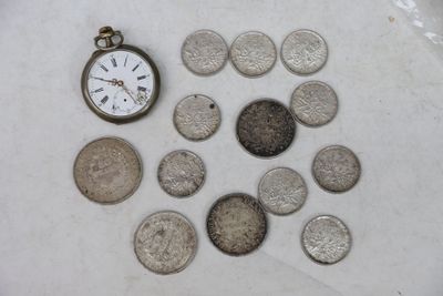 beaucoup de pièces de monnaie et une montre de poche sur la table