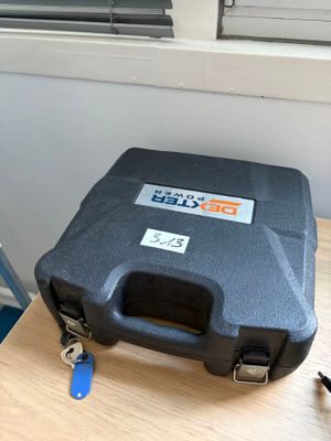 une mallette noire posée sur une table près d'une fenêtre