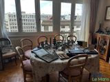 a dining room with a table and chairs and a view of the city