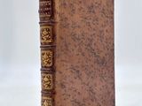 an old book sitting on top of a white surface