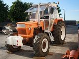 a large orange tractor parked in a parking lot